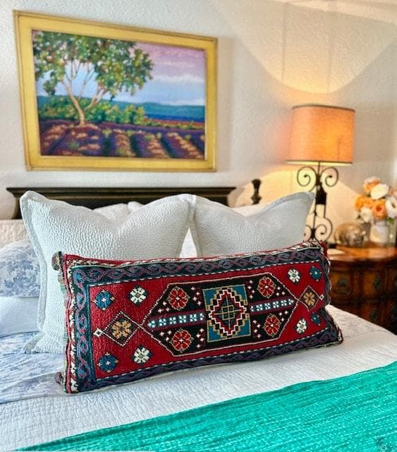 The primary suite includes beautiful local artwork, a ceiling fan, and a closet with hangers for all your items.